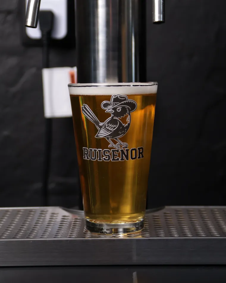 Vaso de cerveza clara de la casa bajo el tirador