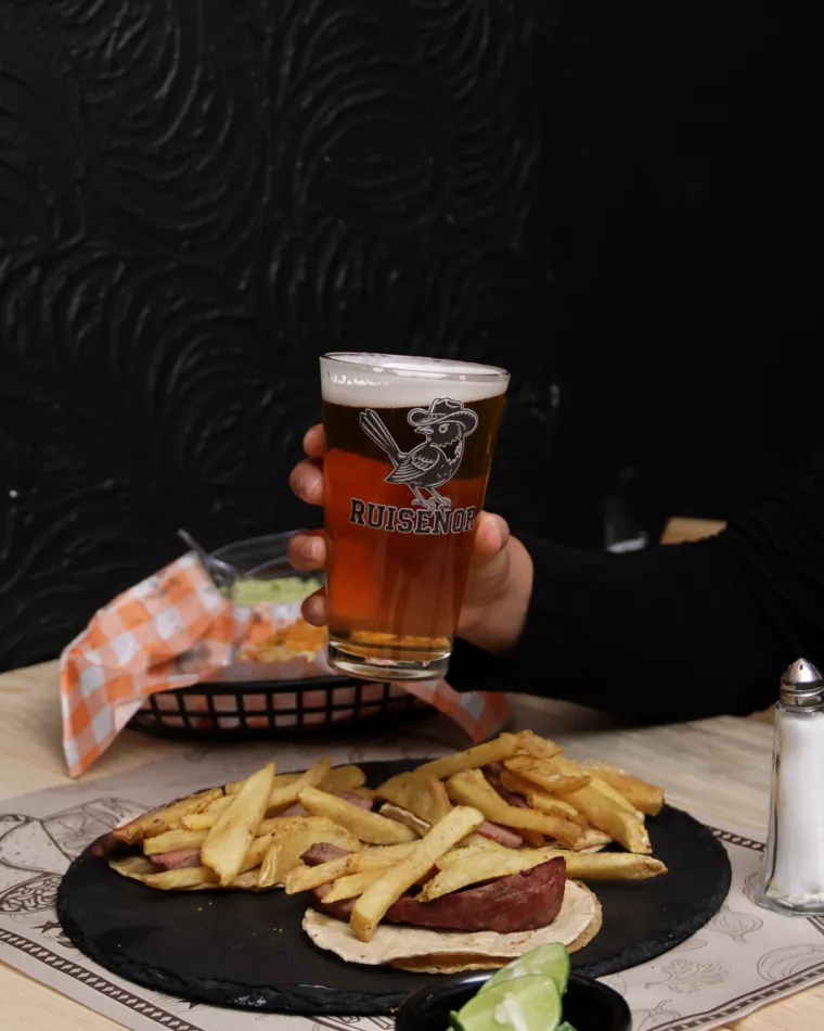 Tacos de rib eye con papas y una cerveza de la casa en alto